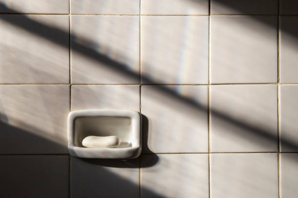 White bathroom wall with white soap and sunshine on the wall