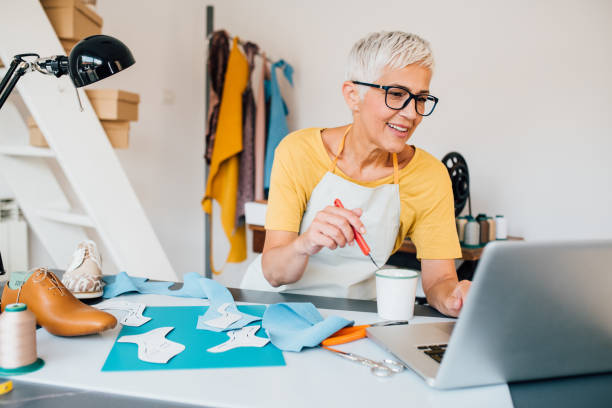 istock Mature woman designing and making leather shoes 1181287667