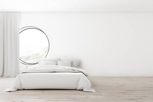 istock White bedroom interior with round window 1181302656