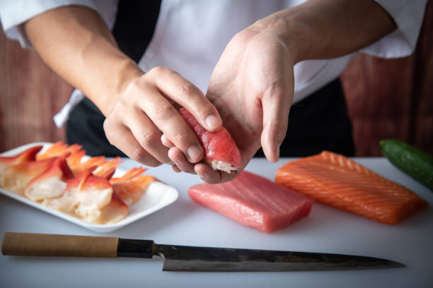chef de sushi japonés haciendo nigiri sushi - nigiri fotografías e imágenes de stock