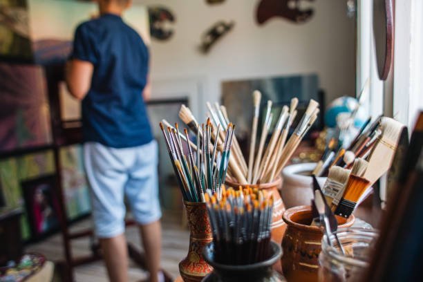 Male artist, painting a new creative painting in his art studio