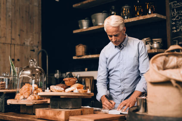 istock Smiling man going over his cafe's accounting for the day 1181306100