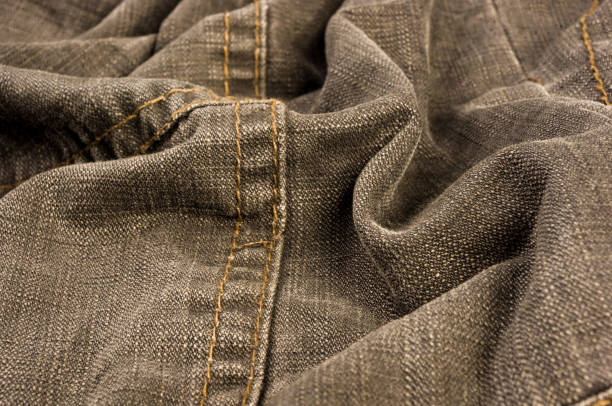 istock clothing items stonewashed cotton fabric texture with seams, clasps, buttons and rivets, macro 1181307599