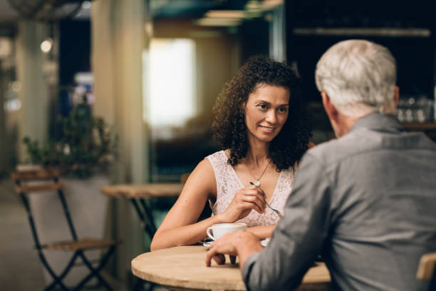 istock Smiling mature couple talking over coffee together in a cafe 1181308792