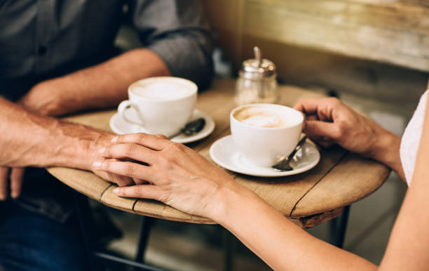 istock Mature couple sitting at a cafe table holding hands 1181310902