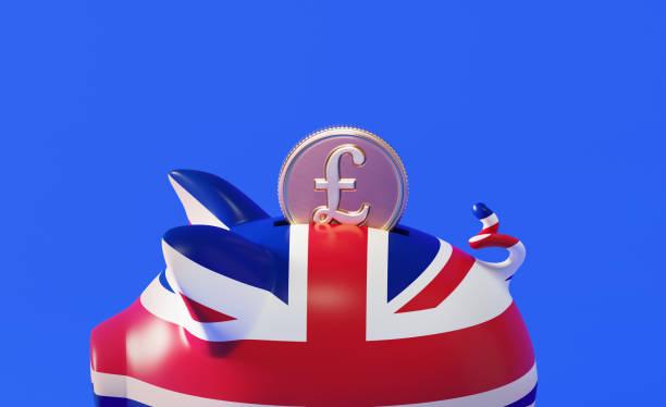 青い背景の上に英国の旗とポンドコインでテクスチャピギーバンク - piggy bank gold british currency pound symbol ストックフォトと画像