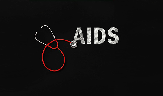 Red stethoscope and AIDS text on blackboard. Horizontal composition with copy space.