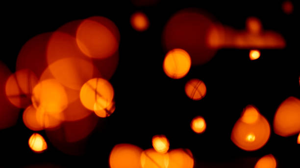 istock orange red festive bokeh lights night glow black 1181315413