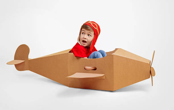 istock Little pilot in cardboard plane looking back 1181317082