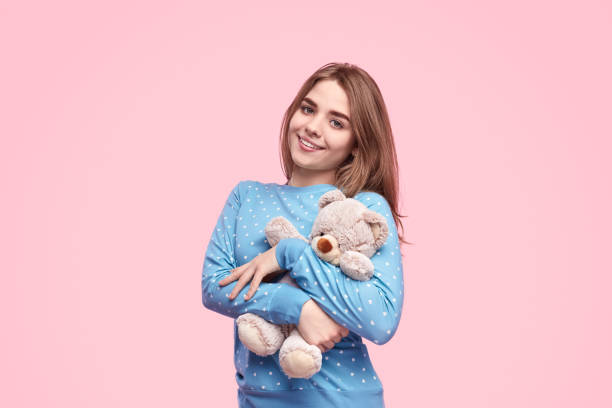 istock Cute teenager embracing teddy bear 1181317113