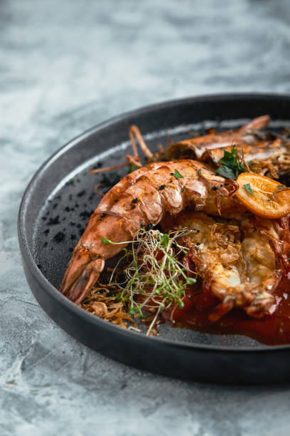 istock Grilled king prawns, with tomato sauce on a gray background, low key. Series concrete background. Food concept, food style, Copy space, food advertising for magazines and social networks 1181321237
