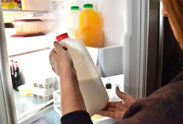 lifestyle, " milk and food in a refrigerator " - human hand gripping bottle holding imagens e fotografias de stock