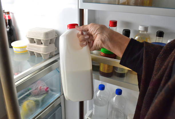 estilo de vida, "jarro de leite, tomado de um refrigerador" - human hand gripping bottle holding - fotografias e filmes do acervo