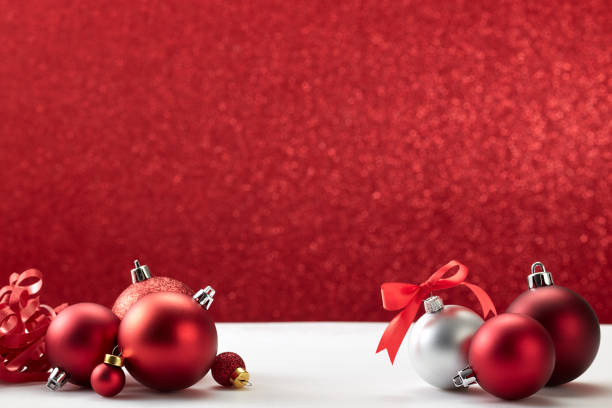many christmas balls on white table red wall
