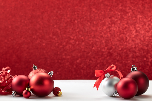 Christmas Ornaments red balls on white table red wall background, copy space for text