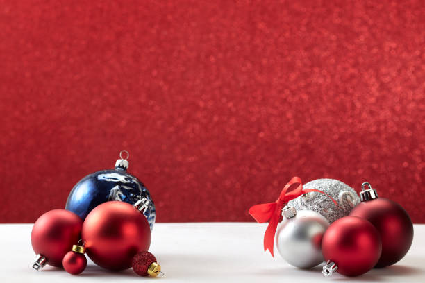 istock many christmas balls on white table red wall 1181325311
