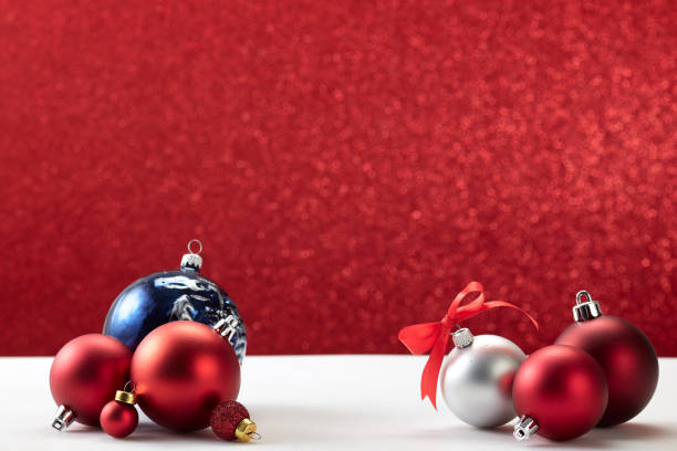 istock many christmas balls on white table red wall 1181325317