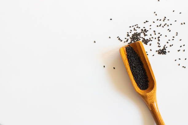 istock Sweet basil seeds in a wooden scoop white background. Isolate. Horizontal with copy space for text and design about superfood and health 1181331480