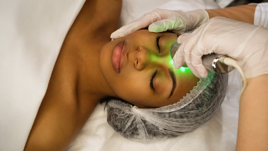 Ultrasound chromotherapy. Hardware cosmetology. Beautician carries out procedure for face skin rejuvenation. Non-surgical cosmetology. Beauty, spa, cosmetology and wellness relaxation concept.