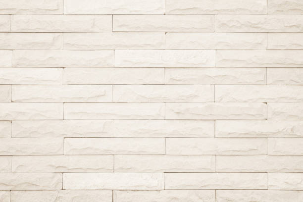 Seamless Cream pattern of decorative brick sandstone wall surface with concrete of modern style design decorative uneven have cracked realmasonry wall of multicolored stones or blocks white cement.