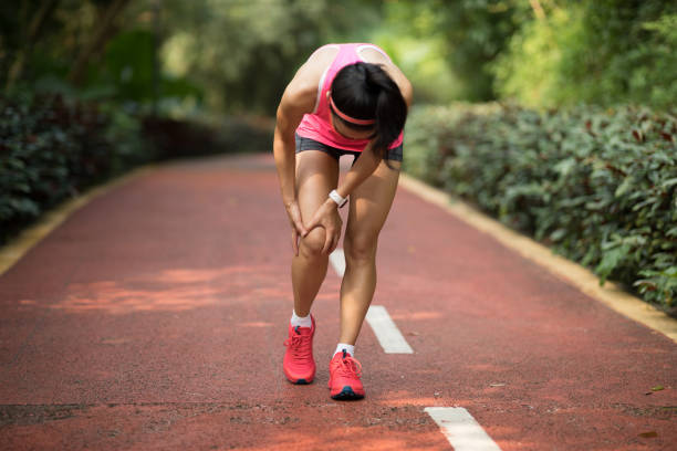 Female runner suffering with sports injury on running Female runner suffering with sports injury on running shin stock pictures, royalty-free photos & images