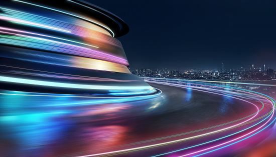 Abstract motion curvy urban road with neon light motion effect applied . Automobile background use concept .