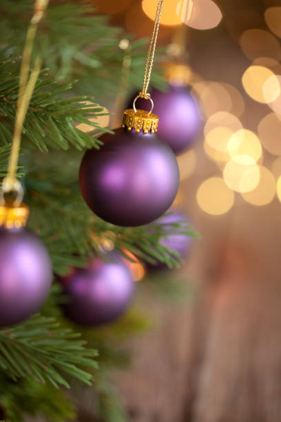 istock Christmas Tree with Purple Baubles and Gold Lights Background 1181340116