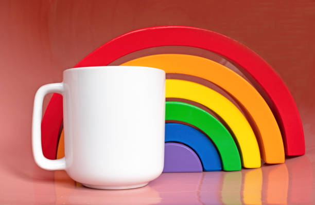 Plain blank white 11oz cup in front of a wooden rainbow toy on a pink shiny surface - simple digital mug mock up