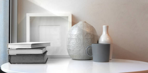 Ceramic vases and mock up frame on white table in minimal workspace