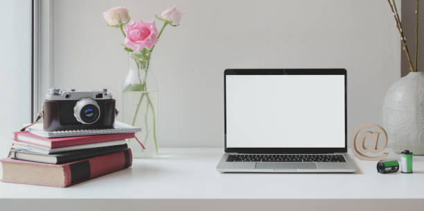istock Open blank screen laptop computer with camera with roses vase and coffee cup 1181343101