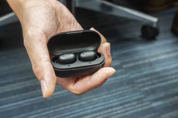 istock close up man hold wireless earphone in charger box for battery 1181345687