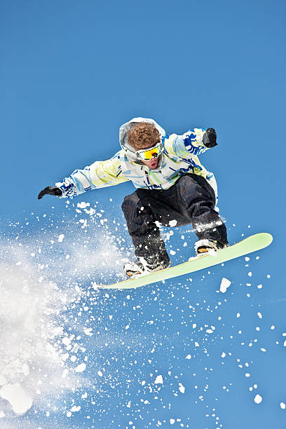 istock Snowboarder Launching Off A Jump Against Blue Sky 118135258