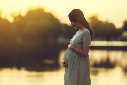 Pregnant woman walks in the park she feels relaxed