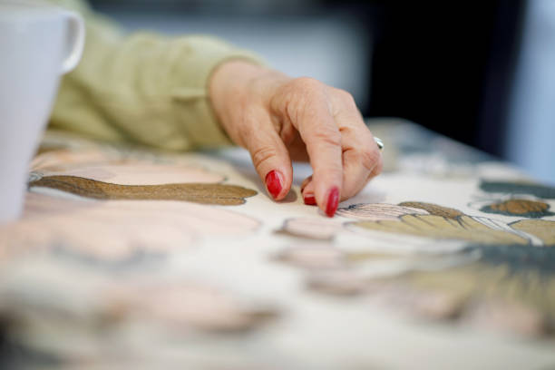 istock Wrinkled female hand resting on dining table 1181359886