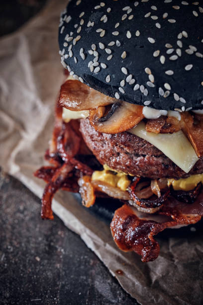 istock Black Burger Buns with Beef Pattie, Cheese, Bacon and Mushrooms 1181360378