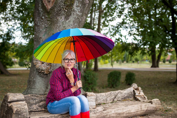 istock Beautiful woman under rainbow umbrella 1181363552