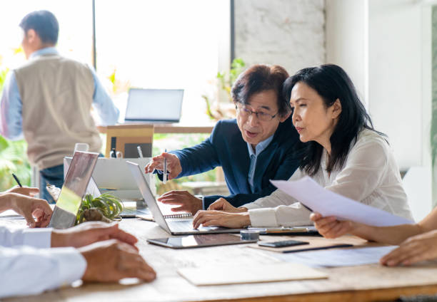 istock Mid adult workers in a modern office 1181364646