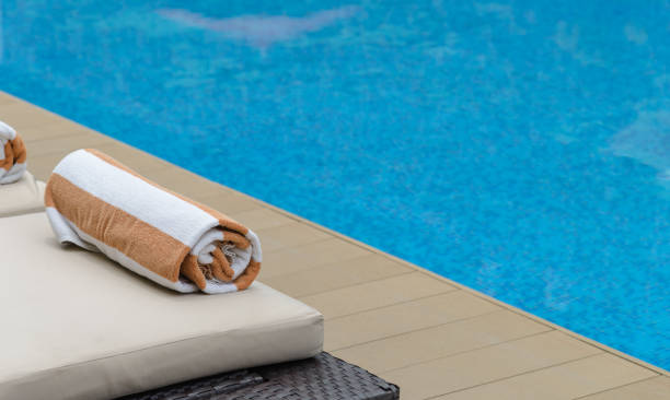 istock Roll soft towel on a sun bed near a swimming pool. 1181364787