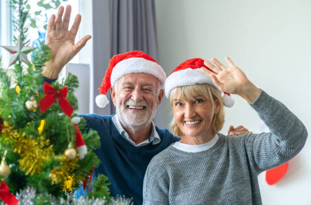 family, holidays, christmas, age and people concept - happy senior couple in celebrating  at home. stock photo
