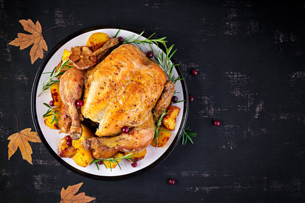 istock Roasted turkey garnished with cranberries on a rustic style table decorated  autumn leaf. Thanksgiving Day. Baked chicken. Top view 1181366868