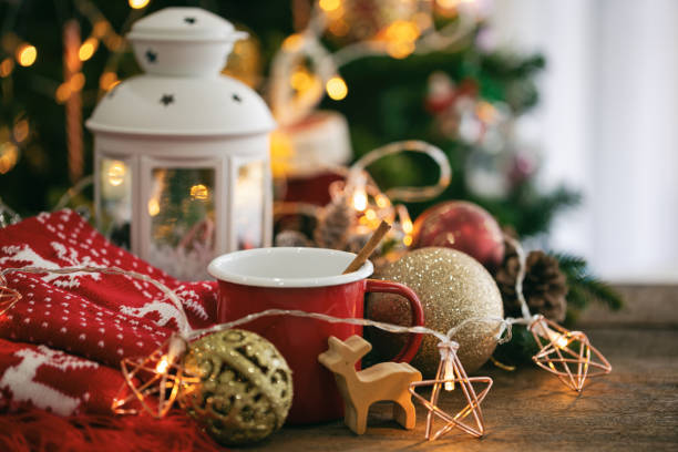 Christmas decoration with red cup of chocolate, red scarf, white lantern, star blinker, balls and bauble reindeer on wood table with copy space. Bokeh Christmas tree wallpaper for xmas celebration. decoración navideña con taza roja de chocolate, bufanda roja, linterna blanca, parpadeo estrella, bolas y renos balbuceos en mesa de madera con espacio de copia. bokeh fondo de pantalla del árbol de navidad para la celebración de navidad.