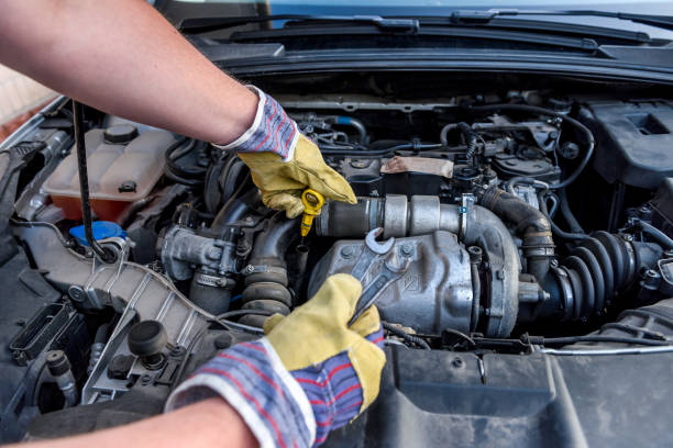 istock Human hands examining car engine in protective gloves close up 1181370450