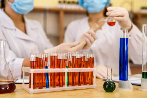 istock Chemists working in laboratory. Young women in protective uniforms with test tubes making experiments 1181370482
