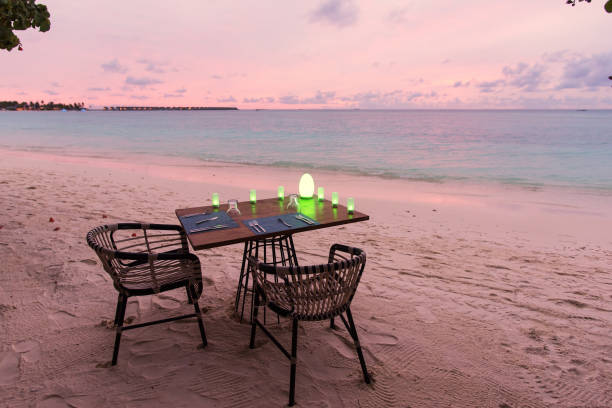istock Open air restaurant table dinner setting on the beach at dusk 1181373699