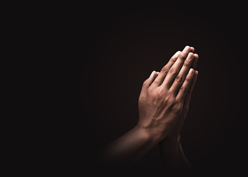 Orando manos con fe en la religión y creyendo en Dios sobre un fondo oscuro. Poder de esperanza, amor y devoción. Namaste o Namaskar las manos gesto. Posición de oración. photo