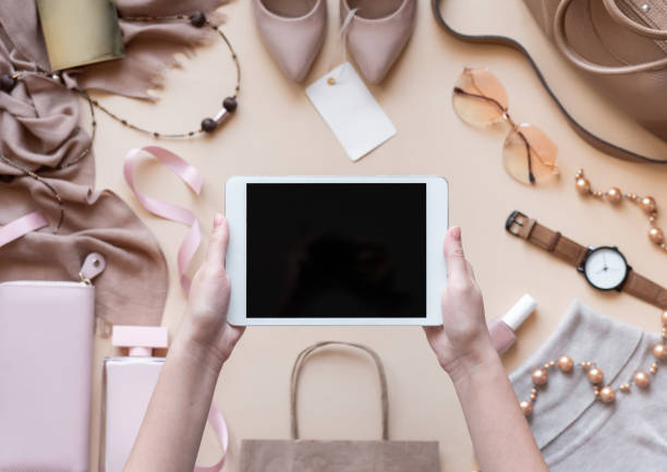 istock Female hands customer hold digital tablet computer mock up blank empty screen on beige fashion women stylish accessories background, online shopping app technology, black friday concept, top view 1181376847
