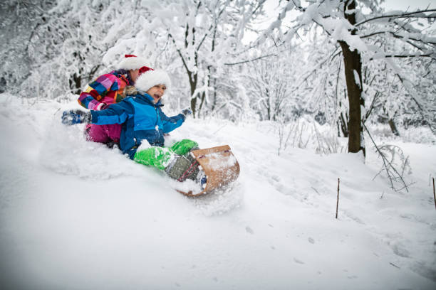 istock Kids sledding on toboggan on Christmas 1181378613