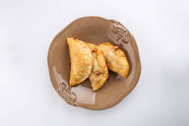 istock fried empanadas with pomegranate on brown plate isolated on white background 1181380517