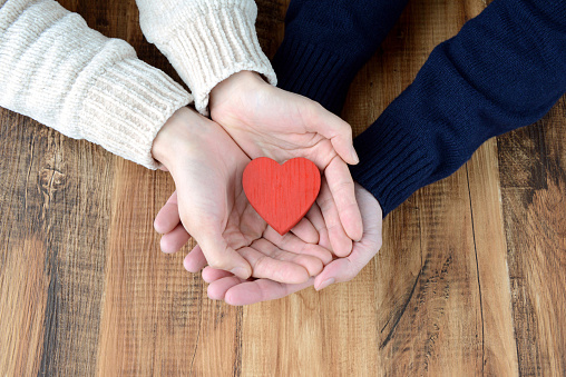 Man and woman's hands having heart object