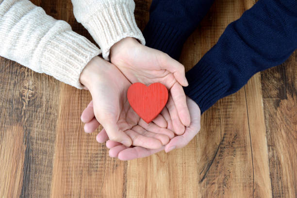 руки мужчины и женщины, имеющие сердечный объект - couple engagement valentines day heart shape стоковые фото и изображения